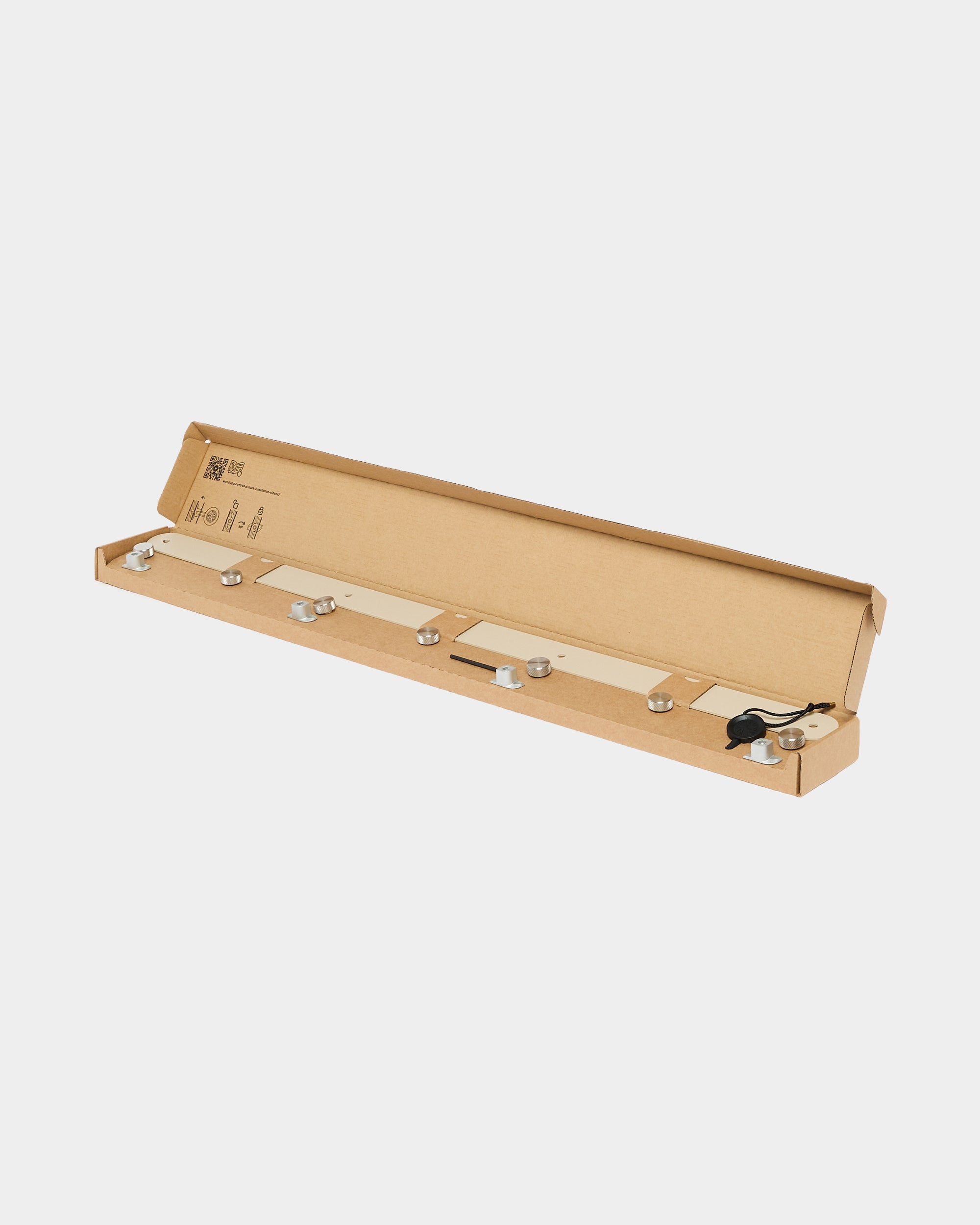 Open rectangular cardboard box containing metal mounting hardware and a black cord for Akupanel acoustic panels, displayed on a white background.